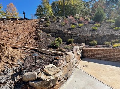 Multi level boulder retaining wall with mulch and plants in Flowery Branch, GA. By SLS