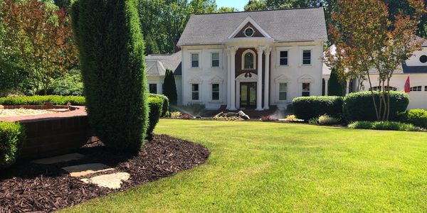 Manicured lawn and formal front yard landscaping in Dacula, GA maintained by Signature Lawn Service
