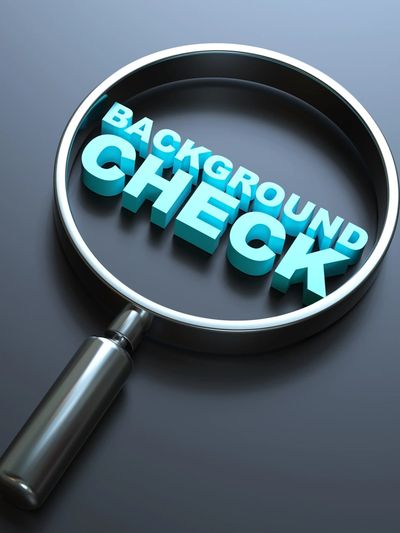 Magnifying glass focusing on the words 'Background Check' in blue 3D letters.