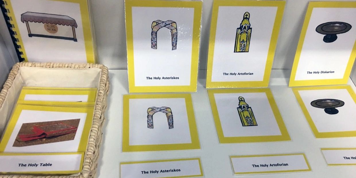 Cards depicting various Holy items with labels in a basket and on a table.