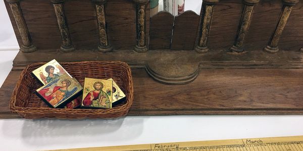 Basket with religious icons placed on a wooden stand.