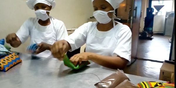 Workers from Choice Coffee Co Ltd Sewing Kitenge cloth over coffee packages for Kilimanjaro Coffee 