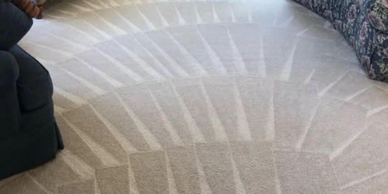 Clean carpet with a circular vacuum pattern between furniture.