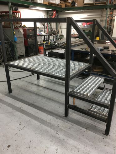 Metal platform with steps in a workshop.