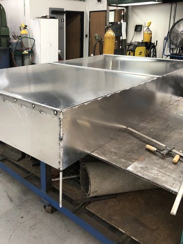Large metal sheet with welds in a workshop.
