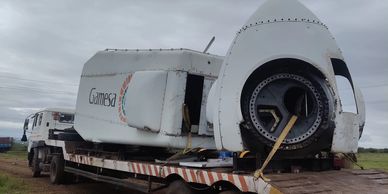Large Gamesa wind turbine parts loaded on a flatbed truck for transport.