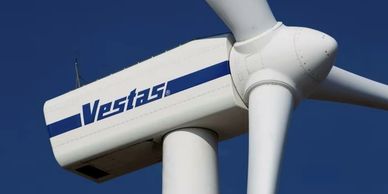 Close-up of a Vestas wind turbine against a clear blue sky.