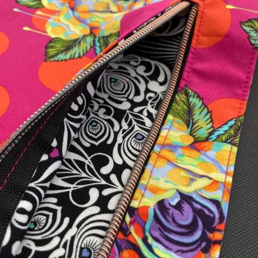Close up of a custom made backpack a zip and brightly coloured pink, red, black and white fabric