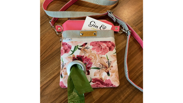 A dog walking cross-body bag with opening for poo bag dispenser