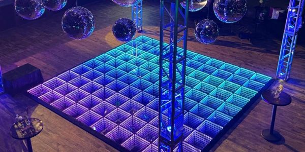 A luxurious event venue showcases a 20-foot by 20-foot LED infinity mirror dance floor illuminated i