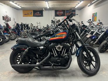 A black Harley-Davidson motorcycle with retro stripes in a showroom.