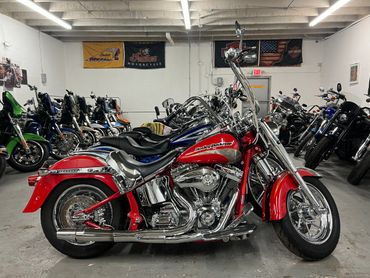 A red Harley-Davidson motorcycle parked indoors among other bikes.