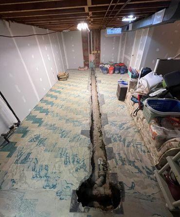 Open trench running along a basement floor.