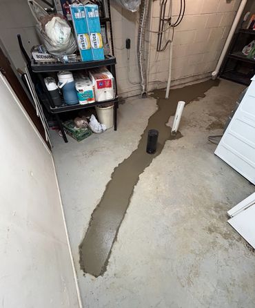 Long narrow concrete patch beside basement storage shelves.