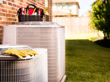 Air conditioning units outside a brick house.