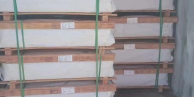 Stacks of packaged wooden planks secured with green straps.
