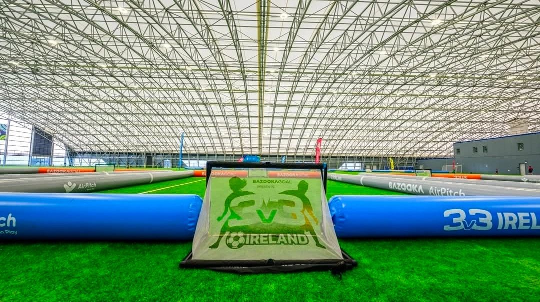 Indoor inflatable soccer pitch with 3v3 Ireland branding.