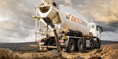 Concrete mixer truck pouring concrete at a construction site.