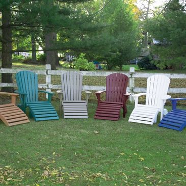 Colored adirondack chairs arranged in a semi-circle are very bright and colorful and stand out.