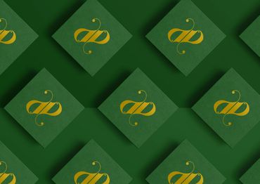 Green cards with a golden stylized ampersand symbol arranged in a pattern.