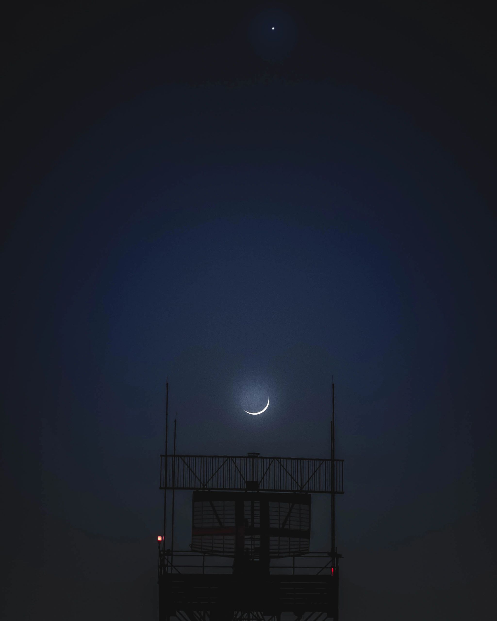 Photo of the night sky with the moon between a satellite and Jupiter above