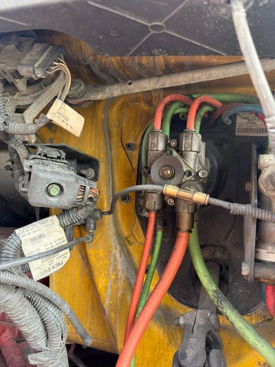 Close-up of colorful cables and wiring inside a vehicle engine compartment.