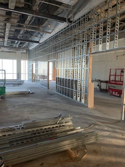 Interior construction site with metal framing and exposed ceiling.