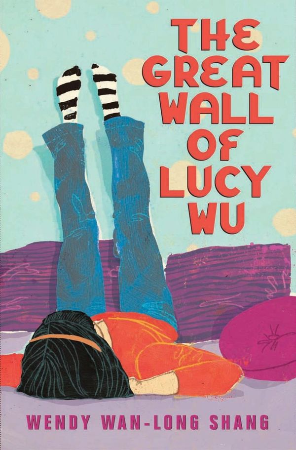 A girl lies on her bed, with her legs up against a wall.