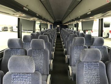 Interior of a clean, empty passenger bus with grey upholstered seats.
