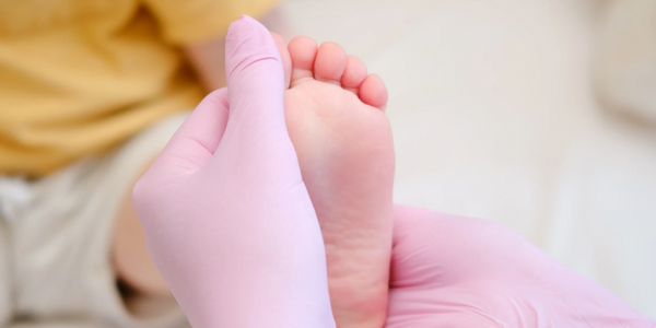 A podiatrist performing a child foot assessment due to flat feet in children providing footwear advice for kids