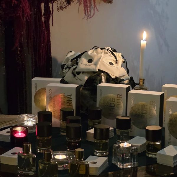 Elegant perfume display with candles and soft lighting.