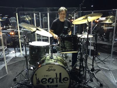 Man playing drums on stage.
