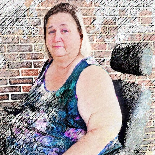 Cheri Mitchell, a blonde woman in a motorized wheelchair wearing a patterned sleeveless top.