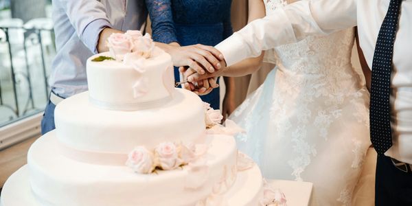 wedding bride and groom and family and friends cutting wedding cake