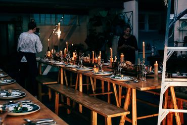 long table with plates, glasses and lit candles