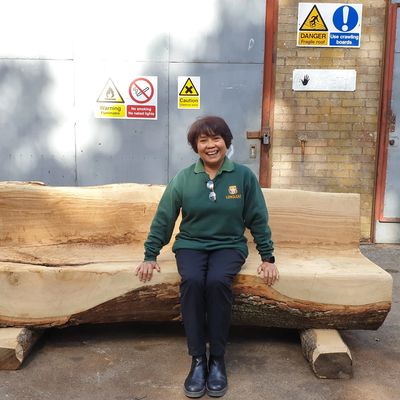 Salmah At Longleat Forestry seated on a bench made from wood from Longleat forest