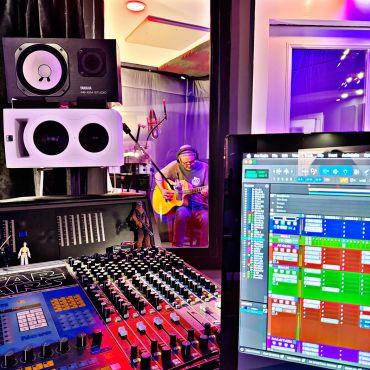Producer recording with guitarist in action.