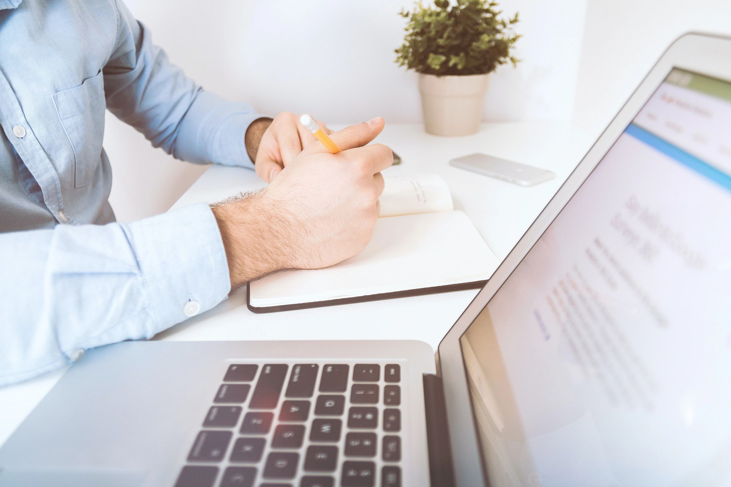 Physical therapist making notes during an online visit with a patient