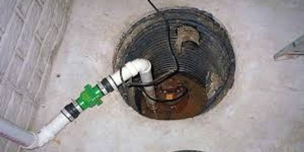 alt="Tapped Out Plumbing technician installing a sump pump in a Denton TX basement"
