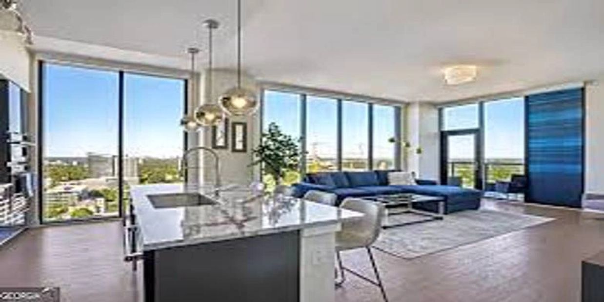 Modern open-concept living area with large windows and city views.