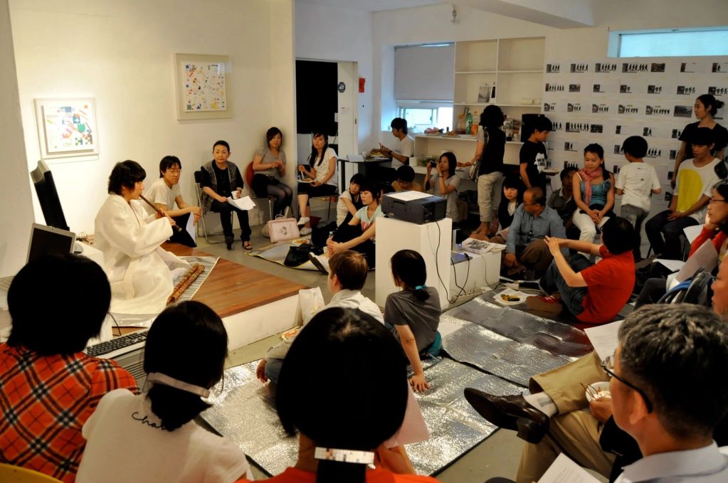 Group of people attending a traditional music performance indoors.