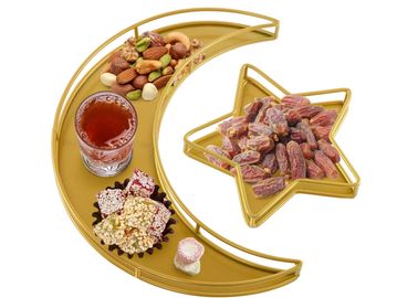 Golden crescent and star trays with nuts, dates, and a drink.
