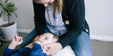 A therapist gently comforting a child during a session.