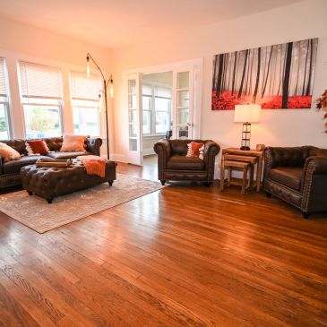 Cozy living room with leather furniture and wooden floor.