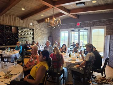Group of people seated at tables in a rustic restaurant.