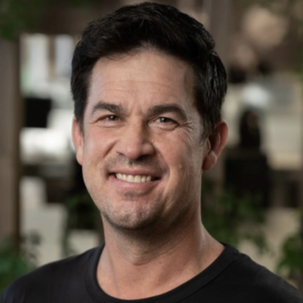 Smiling man with dark hair in a casual black shirt.