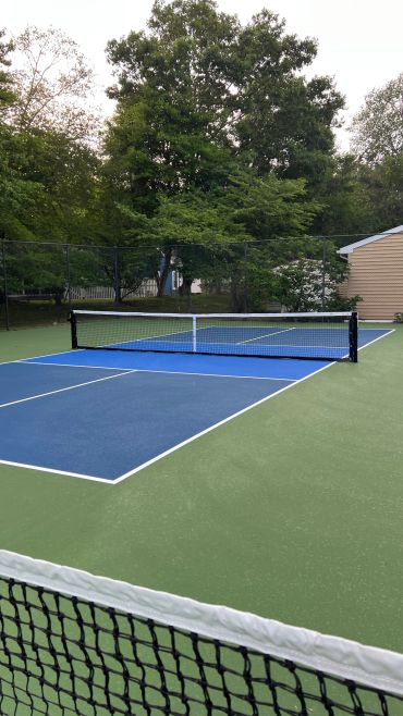 Empty outdoor pickleball court with net.