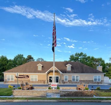 A building with an American flag in front under a clear sky.
