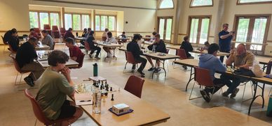 People playing chess in a spacious, well-lit room.