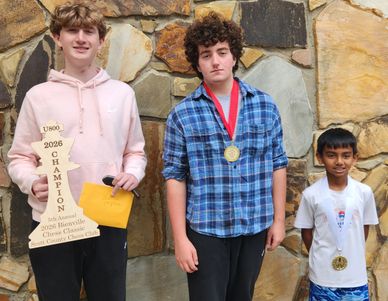 Three boys with medals and awards standing against a stone wall.